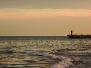 Sunset over the sea. Pier on the foreground
