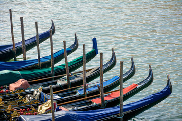 Fototapeta na wymiar Group of gondolas moored at a dock of the Grand Canal in Venice