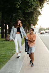 Fototapeta premium Young happy couple wearing the casual style walking in the city and laughing. Couple in love in the city. Urban lovestory