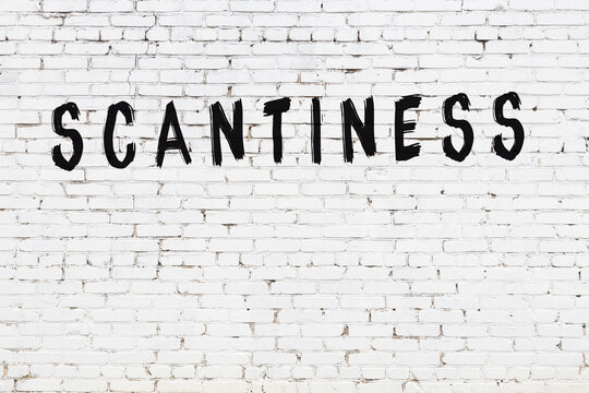 White wall with black paint inscription scantiness on it