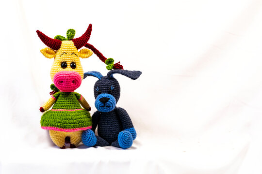 Two Amigurumi dolls a cow and a dog. Photo on a white background.
