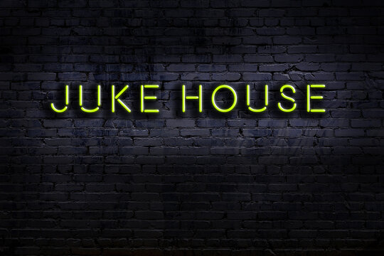 Night view of neon sign on brick wall with inscription juke house