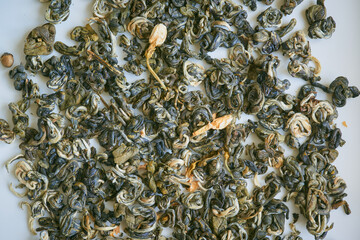 Chinese green jasmine tea with dry flowers on white background close up