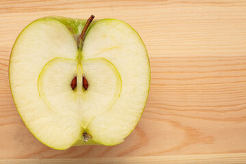 Green sliced apple on a wooden background