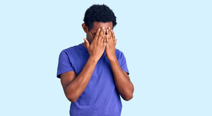 African handsome man wearing casual clothes and glasses with sad expression covering face with hands while crying. depression concept.