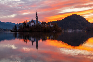 Fototapeta na wymiar Cozy sunrise on Lake Bled against the backdrop of the castle in the Julian Alps in the Tirglav National Park