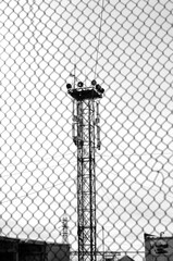 Lighting tower behind a chain-link fence