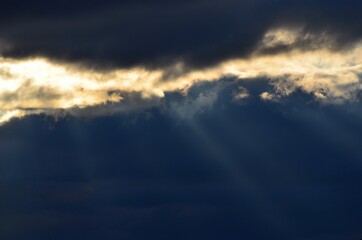 sunrays cutting through thick cloud cover