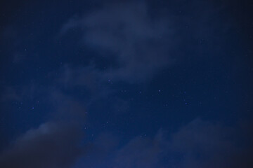 Obraz na płótnie Canvas Stars in the night sky through the clouds on a summer night