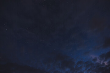 Obraz na płótnie Canvas Stars in the night sky through the clouds on a summer night