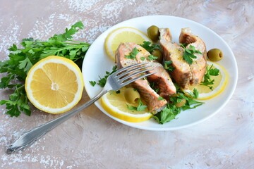 roasted fish with lemon olives and parsley on the beige background