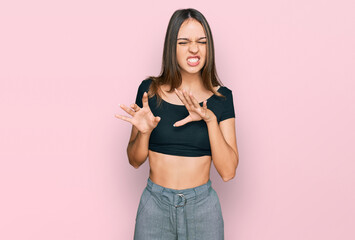 Young brunette woman wearing casual clothes disgusted expression, displeased and fearful doing disgust face because aversion reaction. with hands raised
