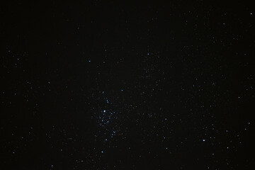 Stars in the night sky through the clouds on a summer night