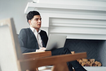 a serious lawyer is a dark-haired man of European appearance in a black business suit. sitting in a modern office and working on a laptop. my favorite job is senior economist at a bank.