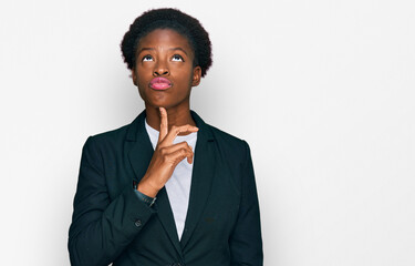 Young african american girl wearing business clothes thinking concentrated about doubt with finger...