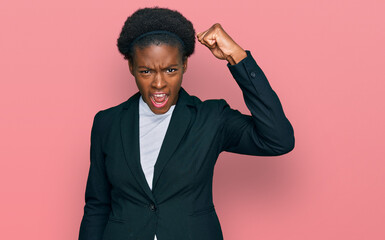 Fototapeta premium Young african american girl wearing business clothes angry and mad raising fist frustrated and furious while shouting with anger. rage and aggressive concept.