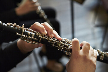 Closeup of a person playing the oboe, indoors - obrazy, fototapety, plakaty