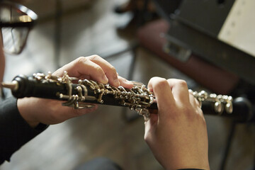 Closeup of a person playing the oboe, indoors