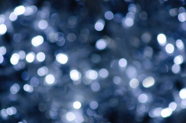 Fototapeta na wymiar Light abstract glowing bokeh lights. Bokeh lights effect. Festive blue luminous background.