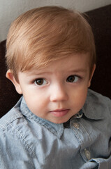 a small boy of European appearance with large brown eyes