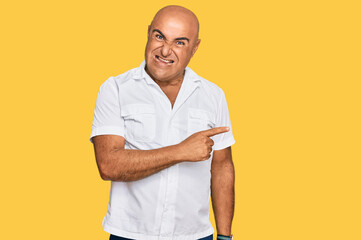 Mature middle east man with mustache wearing casual white shirt pointing aside worried and nervous...