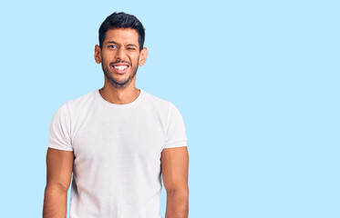 Young latin man wearing casual clothes winking looking at the camera with sexy expression, cheerful...