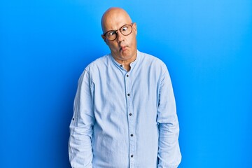 Obraz premium Middle age bald man wearing casual clothes and glasses making fish face with lips, crazy and comical gesture. funny expression.