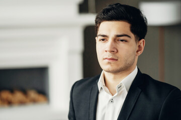 Fototapeta premium portrait of a banker in a bank looking at the camera smiling. a man in a business suit is in a modern, stylish office. general manager.