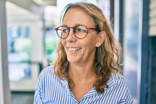 Middle age caucasian woman smiling happy standing at the city.