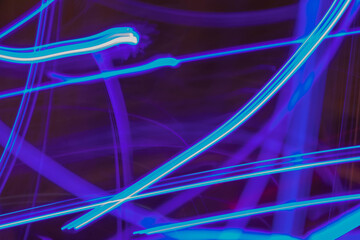 Neon blue lines of lights as an abstract background low exposure