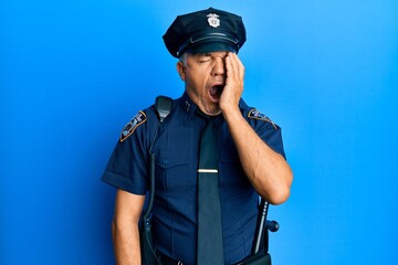 Handsome middle age mature man wearing police uniform yawning tired covering half face, eye and mouth with hand. face hurts in pain.