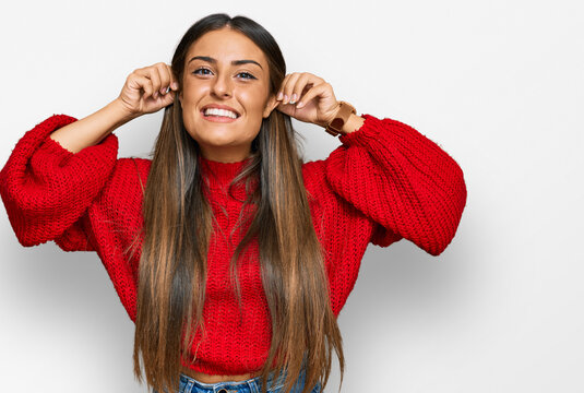 Beautiful hispanic woman wearing casual clothes smiling pulling ears with fingers, funny gesture. audition problem