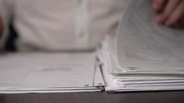 Close-up. Slow motion. Sign Documents. Thin Hands of Elderly Office Worker Transfer Documents. Stack of Paper on the Table.