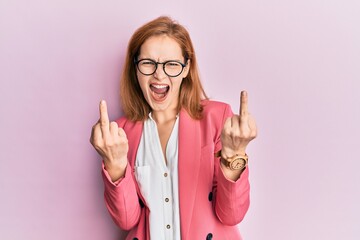 Young caucasian woman wearing business style and glasses showing middle finger doing fuck you bad...