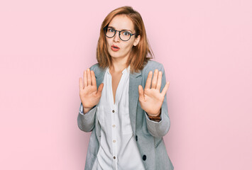 Young caucasian woman wearing business style and glasses moving away hands palms showing refusal...