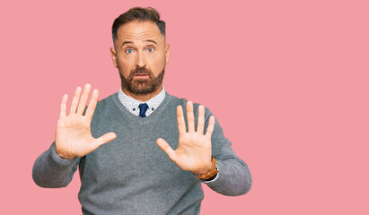 Handsome middle age man wearing business clothes moving away hands palms showing refusal and denial...