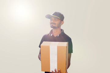 Portrait Of Young Indian Delivery Man Holding Cardboard Box