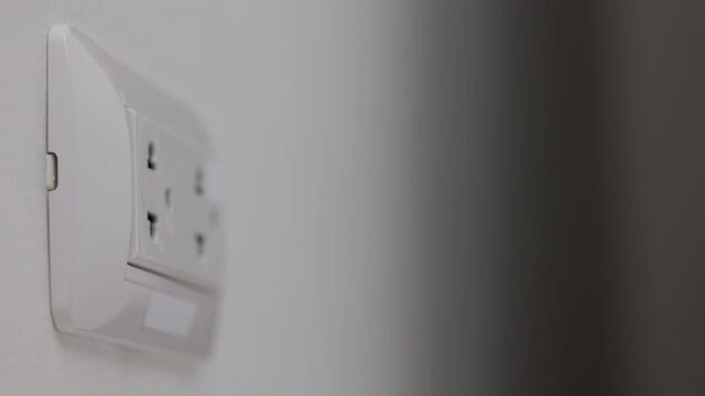 Close up male hand remove the Electric adapter smartphone or laptop plug. Electrical wires and power strips in the house