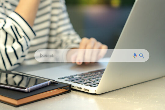 Search Engine Optimization - SEO concept. Closeup of a female hands using laptop computer with a smartphone on the table. Machine learning, AI Artificial intelligence, Smart search, Keyword research.