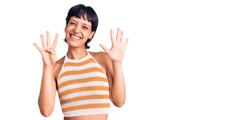 Young brunette woman with short hair wearing casual clothes showing and pointing up with fingers...