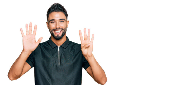 Young man with beard wearing sportswear showing and pointing up with fingers number nine while smiling confident and happy.