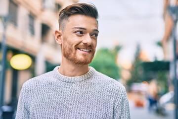 Young caucasian man smiling happy standing at the city.