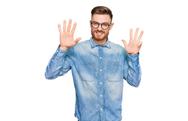Young redhead man wearing casual denim shirt showing and pointing up with fingers number nine while...