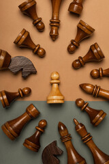 White chess pawn surrounded by black chess pieces on flat background