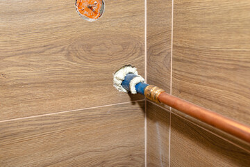Copper pipe for natural gas installations, coming from the wall to the boiler room lined with...