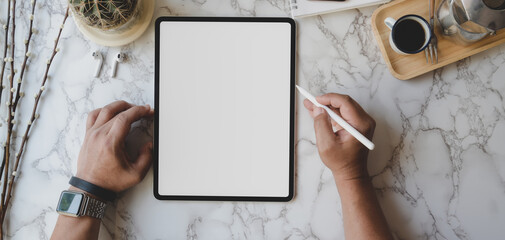 Obraz na płótnie Canvas Cropped Hands Of Businessman Using Blank Digital Tablet At Desk