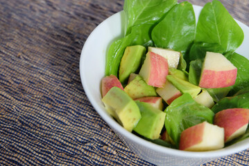 Simple salad contain spinach, apple and avocado with honey dressing.
