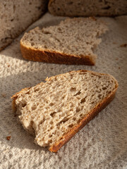 Homemade fresh wheat-rye bread on sourdough on a natural color linen napkin on a white background in the morning light