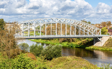 Steel arch bridge across the Msta river in summer day