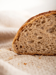 Homemade fresh wheat-rye bread on sourdough on a natural color linen napkin on a white background in the morning light